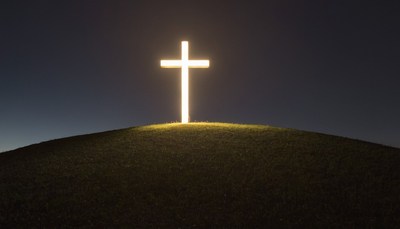 Illuminated cross on hilltop