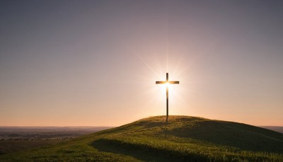 Cross on hilltop at sunset
