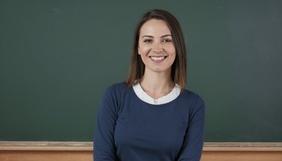 Woman smiling in front of greenboard