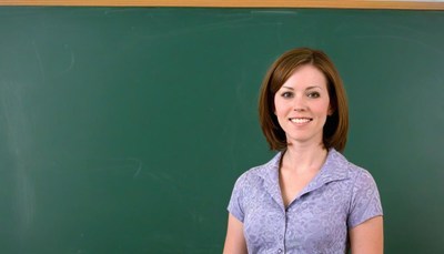 Woman smiling in front of chalkboard