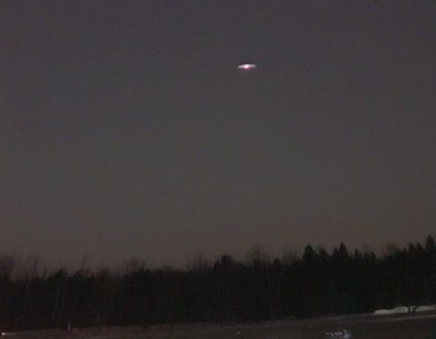 Starry night over forested landscape in winter
