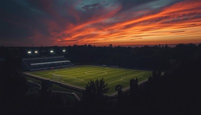 Sunset over a soccer stadium with illuminated field
