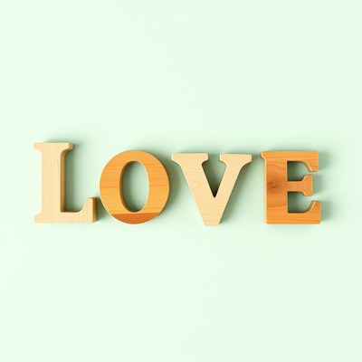 Wooden letters spelling love on soft green background