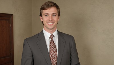 A man in a suit smiles for the camera