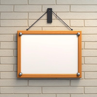 A blank wooden frame hangs on a brick wall