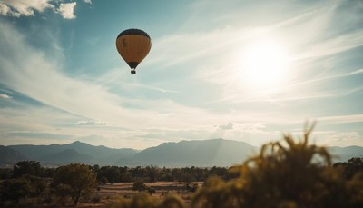 A hot air balloon floats over a mountain range