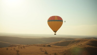 A hot air balloon flies over a desert landscape