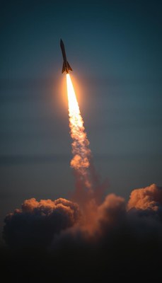 A rocket launches into the evening sky