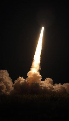 A rocket blasts off into the night sky