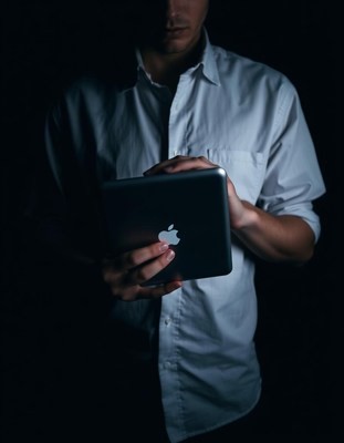 A man uses a tablet in the dark