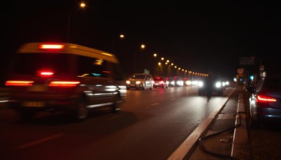 Cars drive on a road at night