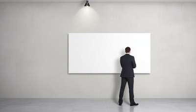 Businessman stands by a blank white board