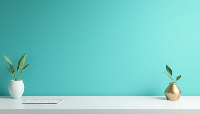 White desk, two plants, keyboard by teal wall