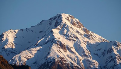 A snow-capped mountain peak under a clear blue sky