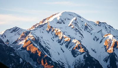A snowy mountain range at sunrise
