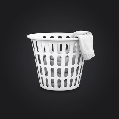White laundry basket of clothes on black background