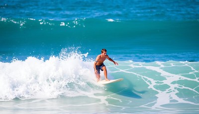 A surfer rides a wave in the ocean
