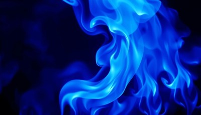 Blue flames dance against a dark background