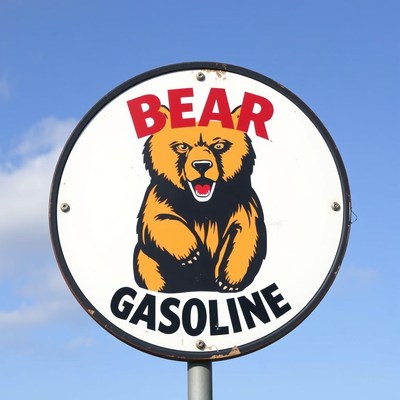 A bear gasoline sign hangs against a blue sky