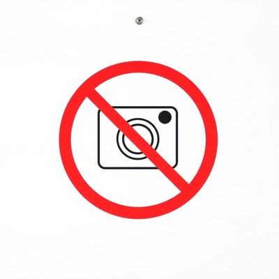 A no photography sign on a white wall
