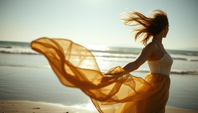 A woman spins on the beach with the wind