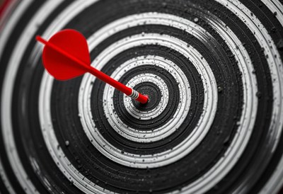 A red dart hits the bullseye of a target