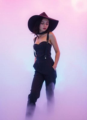 Woman in black jumpsuit and hat in foggy studio