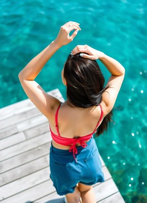 Woman in a red bikini on a dock over blue water