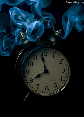 An alarm clock with blue smoke rising from it