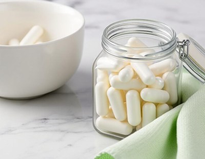 White pills in a glass jar on a marble countertop
