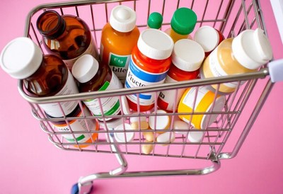 A shopping cart filled with bottles of pills
