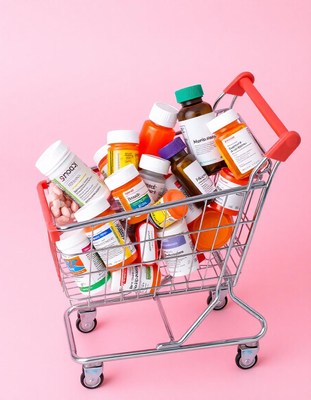 Medicine bottles in a cart on a pink background