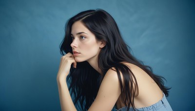 Woman with long dark hair against blue backdrop