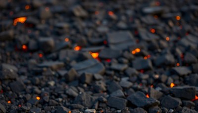 Embers glow in the dying embers of a campfire