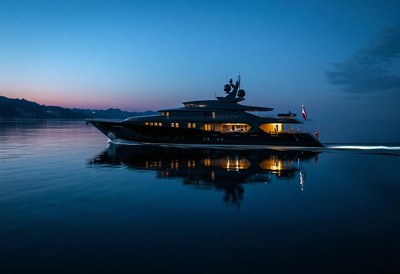 A yacht cruises through the water at dusk
