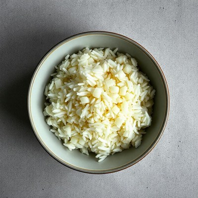 A bowl of cooked rice on a gray surface
