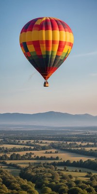 A colorful hot air balloon floats over a rural landscape