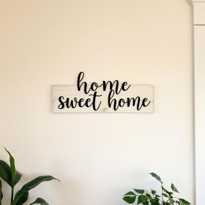 A home sweet home sign hangs on a white wall