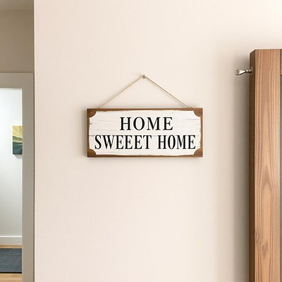 A home sweet home sign hangs on a white wall