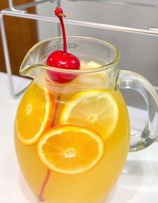 A pitcher of citrus-infused water with a cherry on top