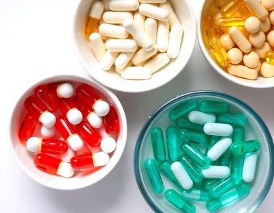 Four bowls of pills on a white surface