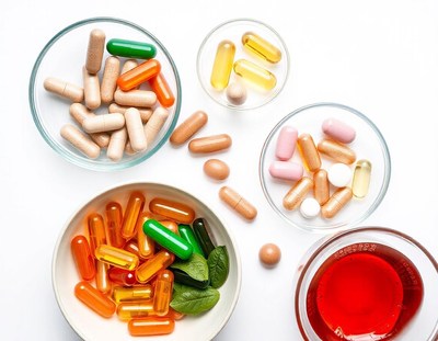 Various pills and capsules in bowls with tea