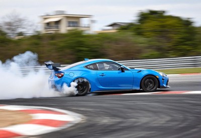 A blue car drifts on a race track