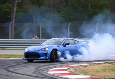 A blue car drifts on a race track