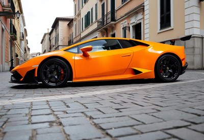 An orange sports car parked in a european city
