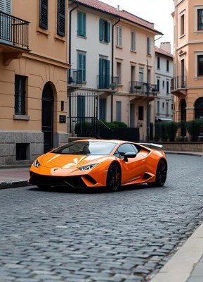 A bright orange sports car is parked on a cobblestone street
