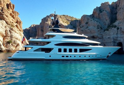 Yacht docked in a bay with rocky cliffs nearby