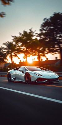 A white sports car drives down a highway at sunset