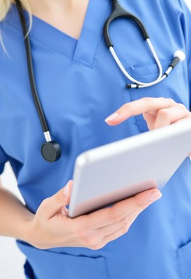 A nurse uses a tablet while working