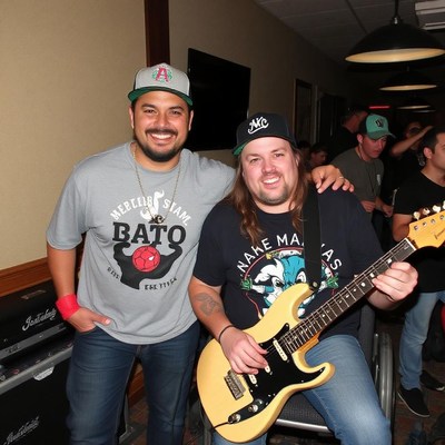 Two men pose for a photo at a concert